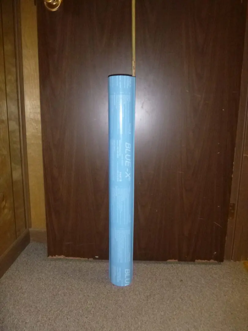 A blue tube of plastic in front of a door.