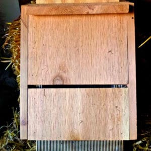 A wooden box sitting on top of a pile of hay.