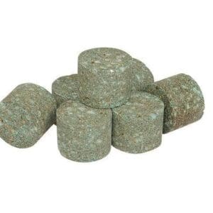 A pile of green fertilizer tablets sitting on top of each other.