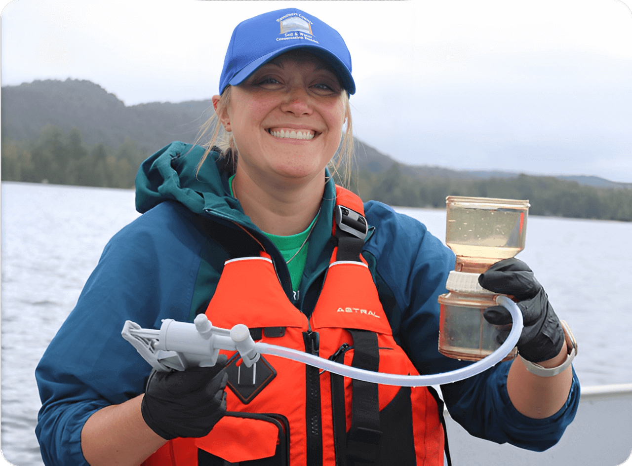 Smiling person with equipment on a boat.