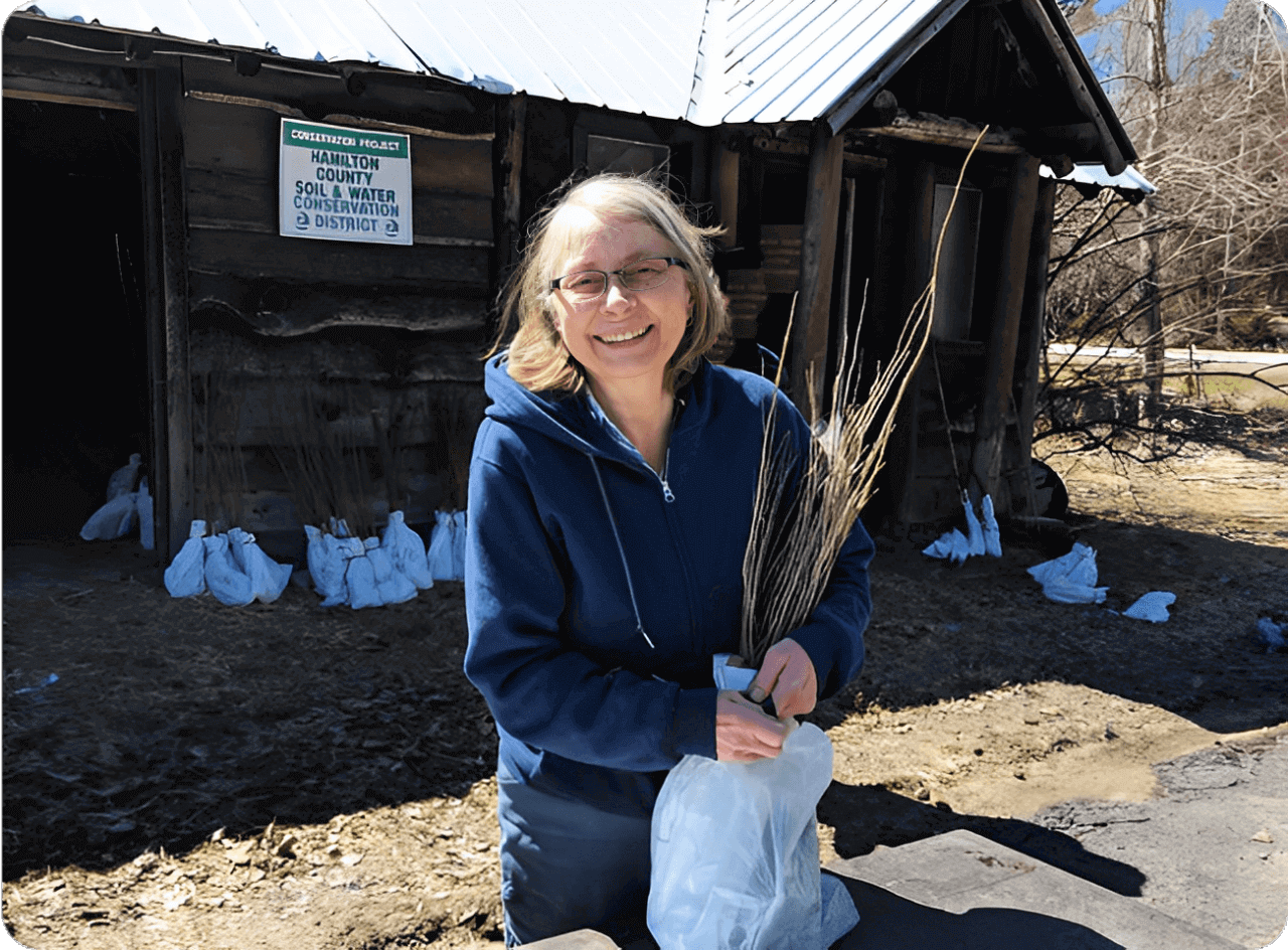 Woman holding twigs in outdoor setting.